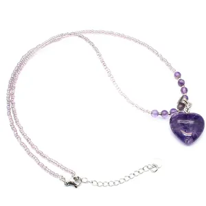 Detail shot of a purple amethyst heart pendant necklace with delicate beaded chain.