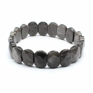 Detailed close-up of a faceted silver sheen obsidian stone bracelet on white background