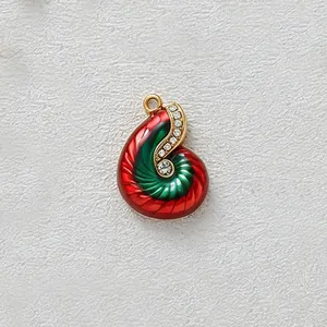 Detailed macro view of conch pendant with red green enamel and sparkling crystals