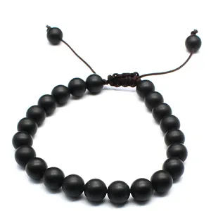 Close-up of 8mm matte black natural stone beads on a hand-woven adjustable bracelet.