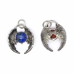 Macro detail of antique silver angel wing pendants featuring natural crystal beads.
