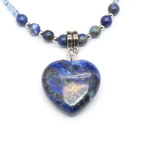 Close-up detail of a heart-shaped blue natural stone pendant with a beaded necklace