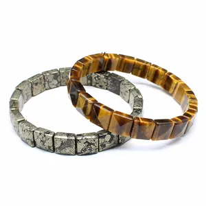 Detailed view of square-cut tiger eye and pyrite stone bracelets on white background