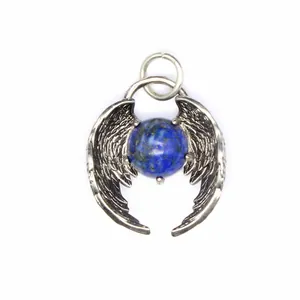 Macro detail of a natural lapis lazuli bead nestled in silver angel wings pendant.