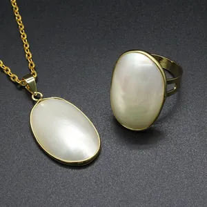 Detailed view of handmade Mabe pearl pendant and ring set in golden setting
