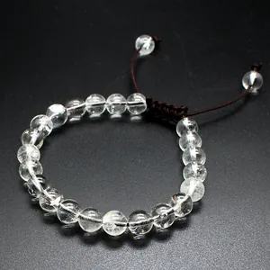 Detailed view of clear 8mm natural stone beads on a dark braided cord charm bracelet.
