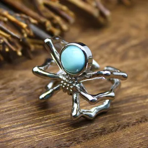 Detailed macro view of a silver spider open ring with a round blue natural stone