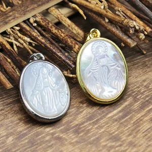 Detailansicht von geschnitzten Maria-Anhängern aus Muschel in Gold- und Silberrahmen