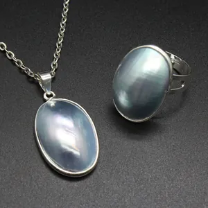 Detail view of handmade Mabe pearl shell pendant and adjustable ring set with iridescent sheen