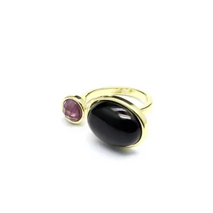 Gros plan d'une bague vintage plaquée or avec pierre noire et cristal violet