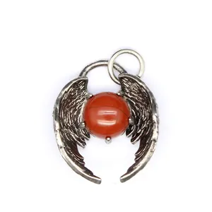 Detailed macro view of angel wing pendant featuring a round red natural stone bead center