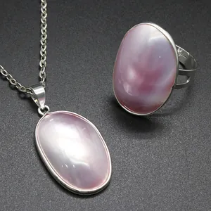 Close-up detail view of natural pink oval sea shell pendant necklace and ring set
