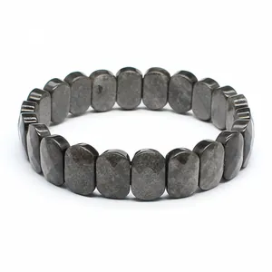 Vue détaillée de perles en pierre naturelle facettée gris foncé sur un bracelet élastique