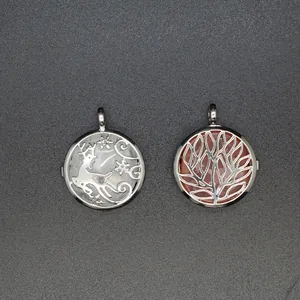 Detail of two stainless steel lockets with reindeer and tree of life motifs over rose quartz.