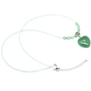 Close-up of green heart stone pendant with light green beaded chain necklace