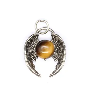 Close-up detail of vintage silver angel wings pendant featuring a round tiger eye stone