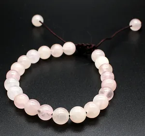 Detailed view of 8mm natural pink rose quartz stone beads on a handmade braided bracelet