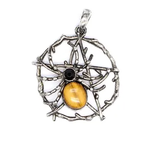 Detalle de un colgante vintage de telaraña en plata con piedra ojo de tigre amarilla