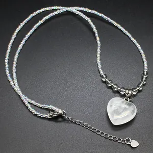 Close-up of iridescent acrylic bead necklace featuring a heart-shaped natural stone pendant