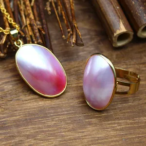 Close-up of elegant pink Mabe pearl pendant and ring set with golden finish