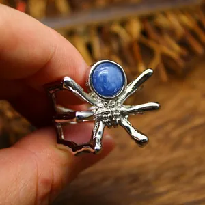 Macro detail of a silver-toned spider ring featuring a polished blue kyanite gemstone