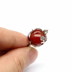 Détail d'une bague en argent avec agate rouge ronde et accent floral en cristal