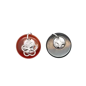 Détail macro de pendentifs beignets en agate naturelle avec breloques papillon en argent
