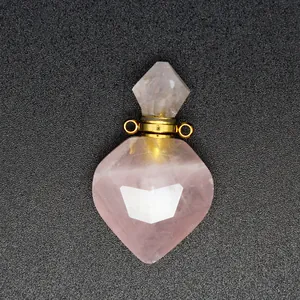 Nahaufnahme eines herzförmigen Parfümflaschen-Anhängers aus Rosenquarz mit goldenen Ösen