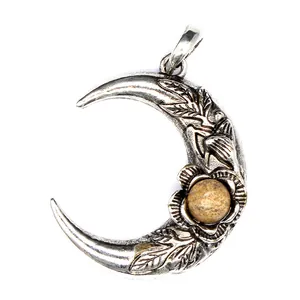 Detalle de colgante de luna vintage en tono plateado con ojo de tigre y grabado floral.