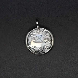 Close-up of a silver reindeer and snowflake filigree pendant with white stone inlay