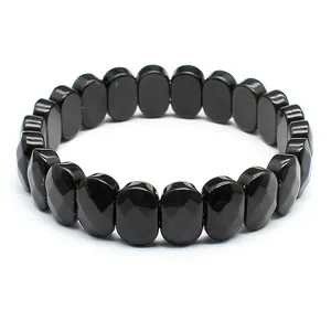 Détail macro montrant les facettes polies d'un bracelet en pierre naturelle noire