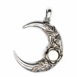 Primer plano detallado del colgante de luna de plata vintage con piedra blanca