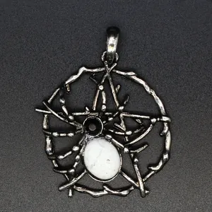 Primer plano detallado de un colgante de telaraña plateado con piedra natural blanca