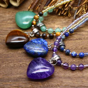 Detailed macro view of natural stone heart pendants including amethyst and beads