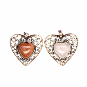 Detailed view of two vintage filigree heart pendants with goldstone and rose quartz gemstones