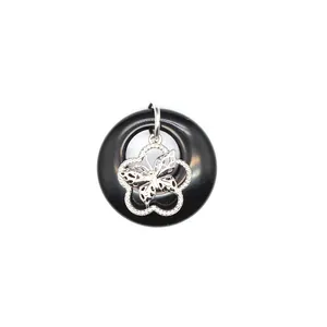 Vue détaillée d'un pendentif en agate noire avec une breloque papillon en filigrane d'argent.