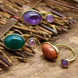 Gros plan de bagues vintage serties de pierres naturelles sur fond de bois rustique.