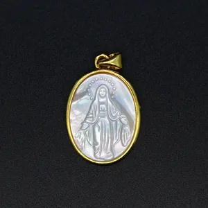 Nahaufnahme eines Anhängers aus Perlmutt mit geschnitztem Symbol der Jungfrau Maria.