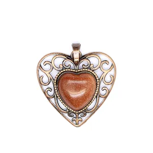 Detail view of a vintage hollow-out heart pendant with a sparkling goldstone gemstone