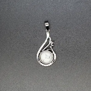 Detail of silver teardrop pendant with round white howlite stone and crystal accents