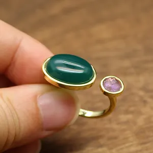 Vue rapprochée d'une bague rétro avec une pierre verte ovale et un cristal rose