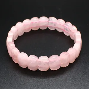 Détail en gros plan des perles facettées en quartz rose naturel sur un bracelet élastique