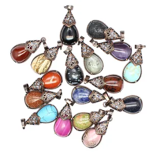 Group of teardrop natural stone pendants with antique copper filigree caps in various colors.