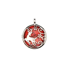 Detailed view of silver-tone circular reindeer pendant with vibrant red marbled stone background