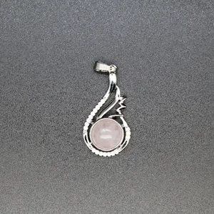 Close-up of elegant silver-tone pendant featuring a round pink crystal and pavé accents