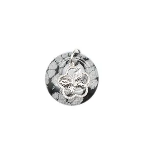 Détail macro du pendentif donut en obsidienne flocon de neige avec papillon argenté