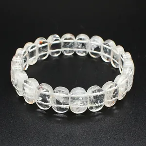 Vue détaillée d'un bracelet en perles de cristal blanc naturel sur un fond noir texturé.