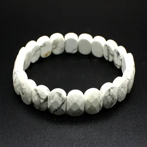 Vue détaillée d'un bracelet en pierre de howlite blanche facettée sur fond noir texturé