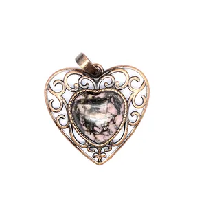 Close-up of vintage heart pendant with natural rhodonite and ornate bronze metalwork