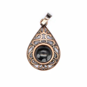 Detailed view of a teardrop-shaped openwork pendant with a natural snowflake stone.